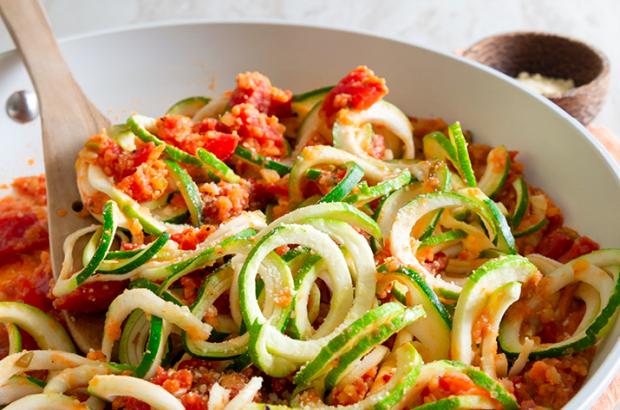 Zucchini noodles on a plate topped with lentil Bolognese sauce