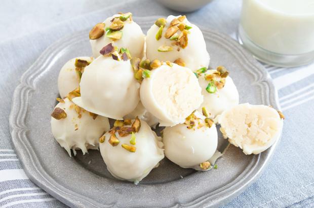 Platter of white sugar cookie truffles with crushed pistachios on top