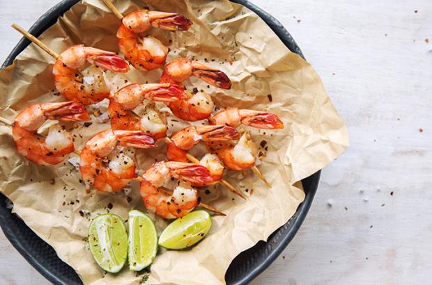 Grilled shrimp on skewers with a lime wedge