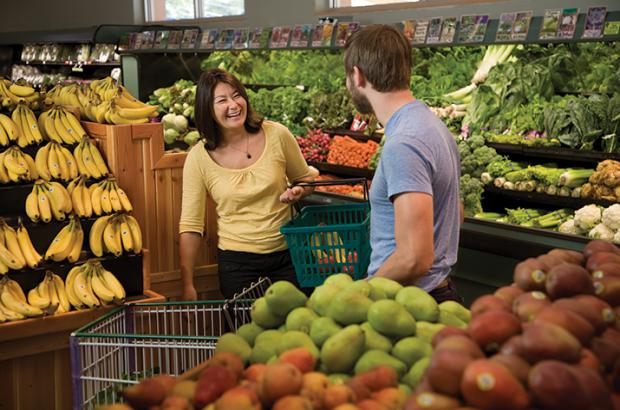 Two shoppers share a laugh while shopping at a food co-op