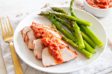 Grilled Pork Tenderloin with Rhubarb Barbecue Sauce plated with steamed asparagus