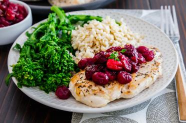 Plate of Maple Cranberry Chicken with sides of broccolini and rice