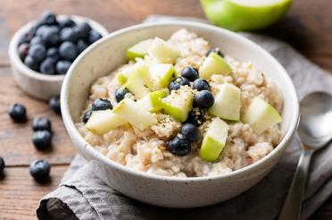 Bowl of oatmeal with apples, blueberries and sesame seeds