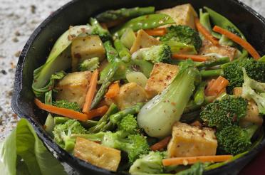 Cast iron skillet with broccoli, bok choy, tofu, carrot stir-fry