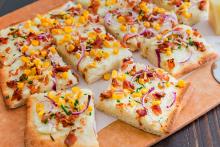 Mashed Potato and Bacon Pizza sliced on a cutting board