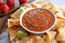 Roasted Tomato Salsa in a bowl with Homemade Chips on a platter
